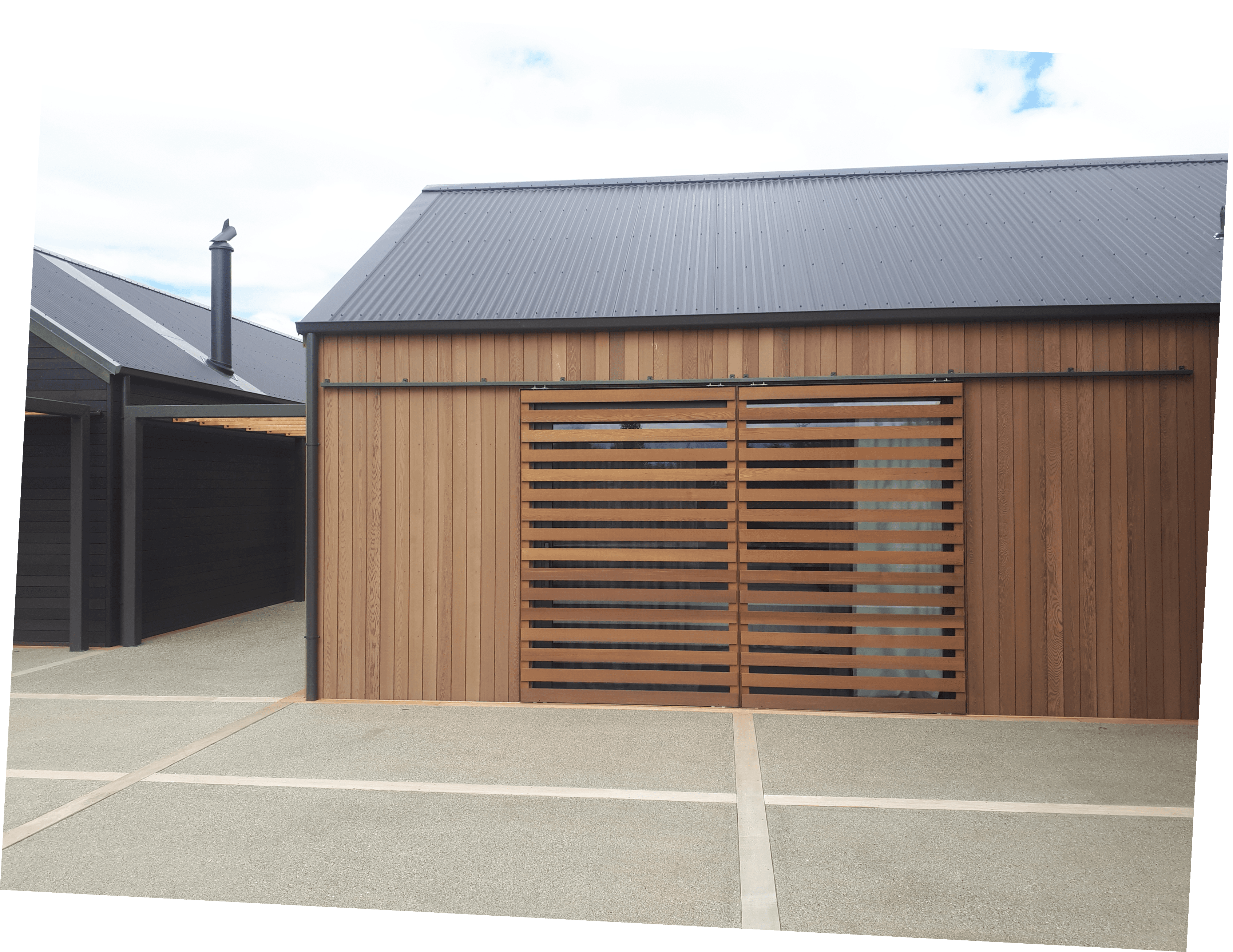 Modern home with vertical wood siding, horizontal window louvers, and a corrugated metal roof.
